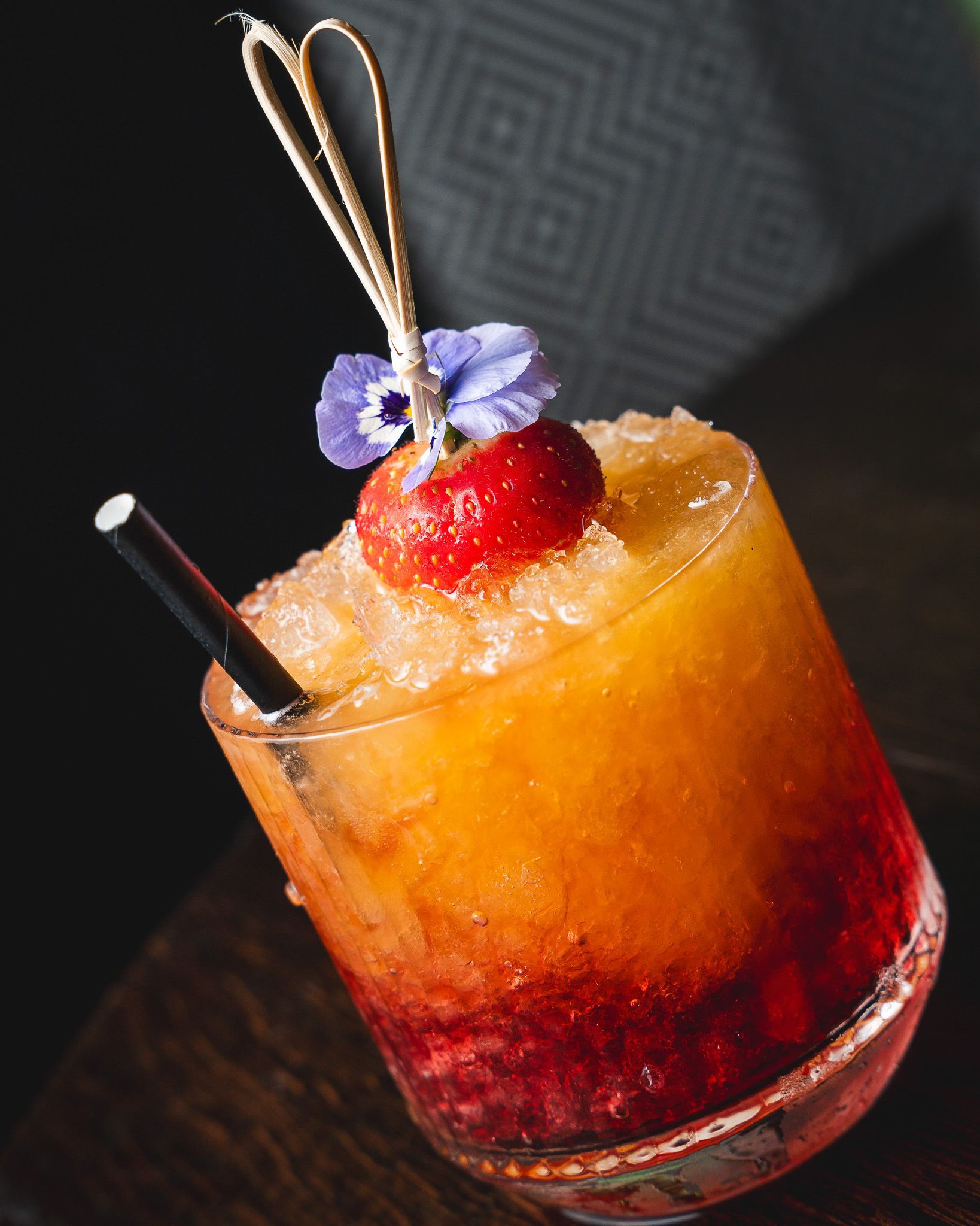 A vivid orange cocktail garnished and ready to serve