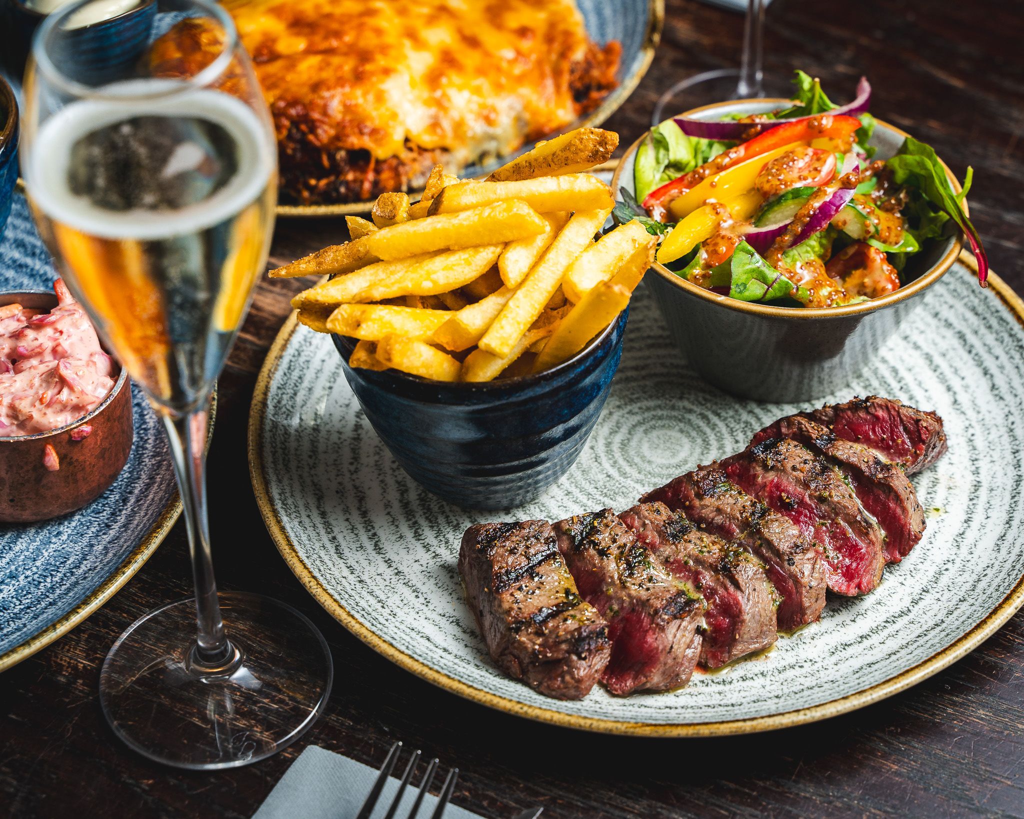 Sliced Tomahawk steak served with golden fries and salad
